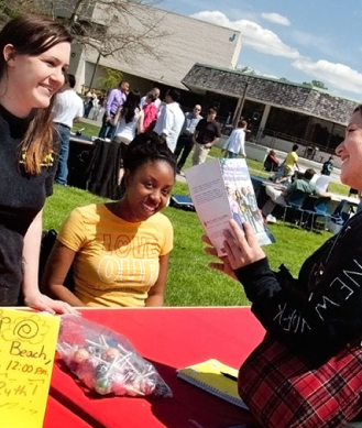 3 students at an information fair in the quad