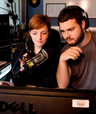 two students broadcasting live in the radio station