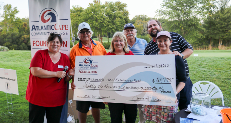 Atlantic Cape Foundation golf tournament organizers holding oversized check