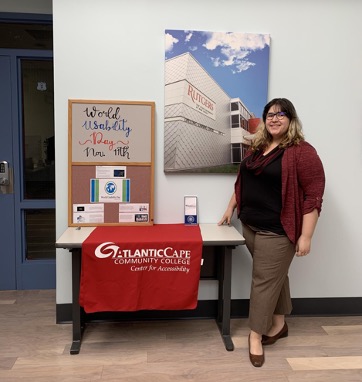Juliana Torres, Office Coordinator, Center For Accessibility, stands next to an information table. 