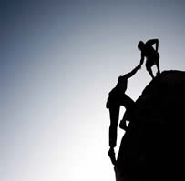 rock climbers helping each other climb