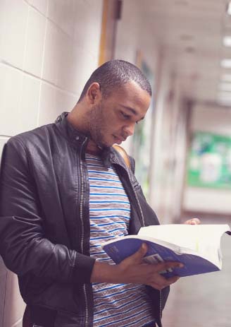 student resources man reading handbook in hallway