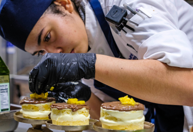 Student chef intently eyeing her culinary creation